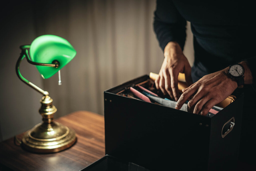 person looking through box of papers